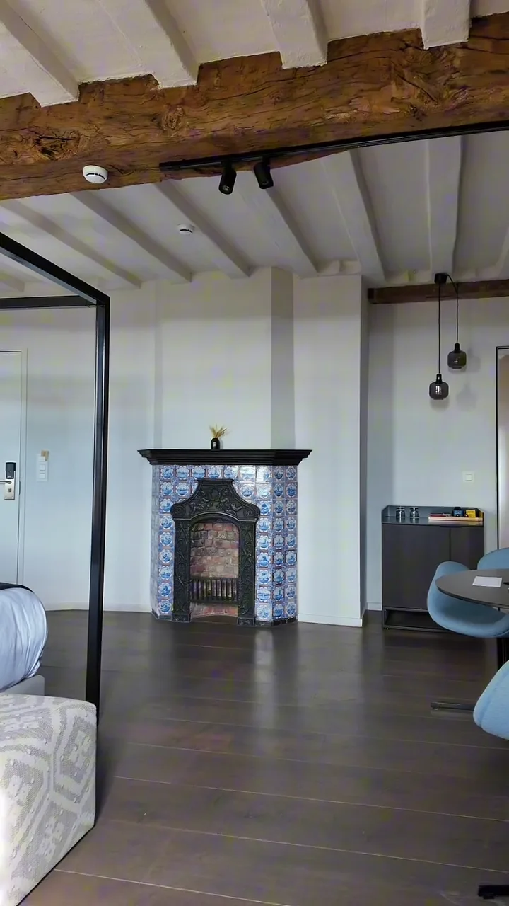 Reel : chambre sous poutres apparentes avec une cheminée en faïence de Delft