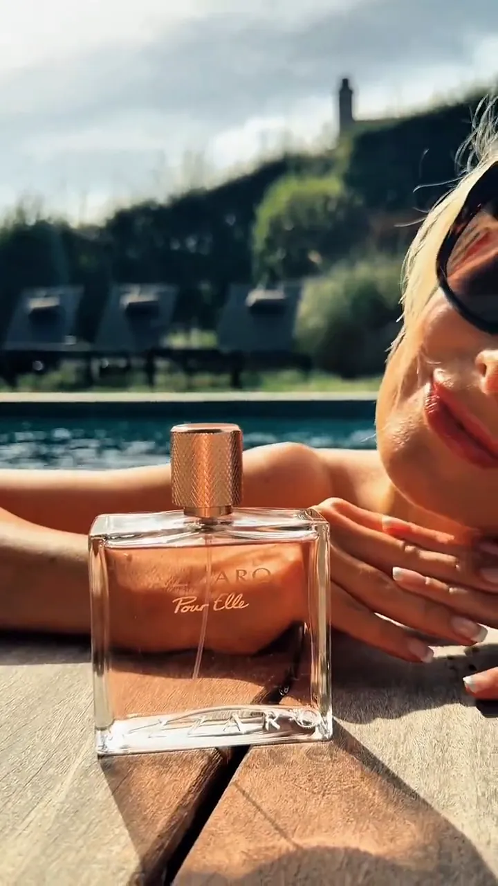 Reel : le flacon Azzaro Pour Elle posé sur un ponton en bois, Laetitia Mariette allongée au bord de la piscine